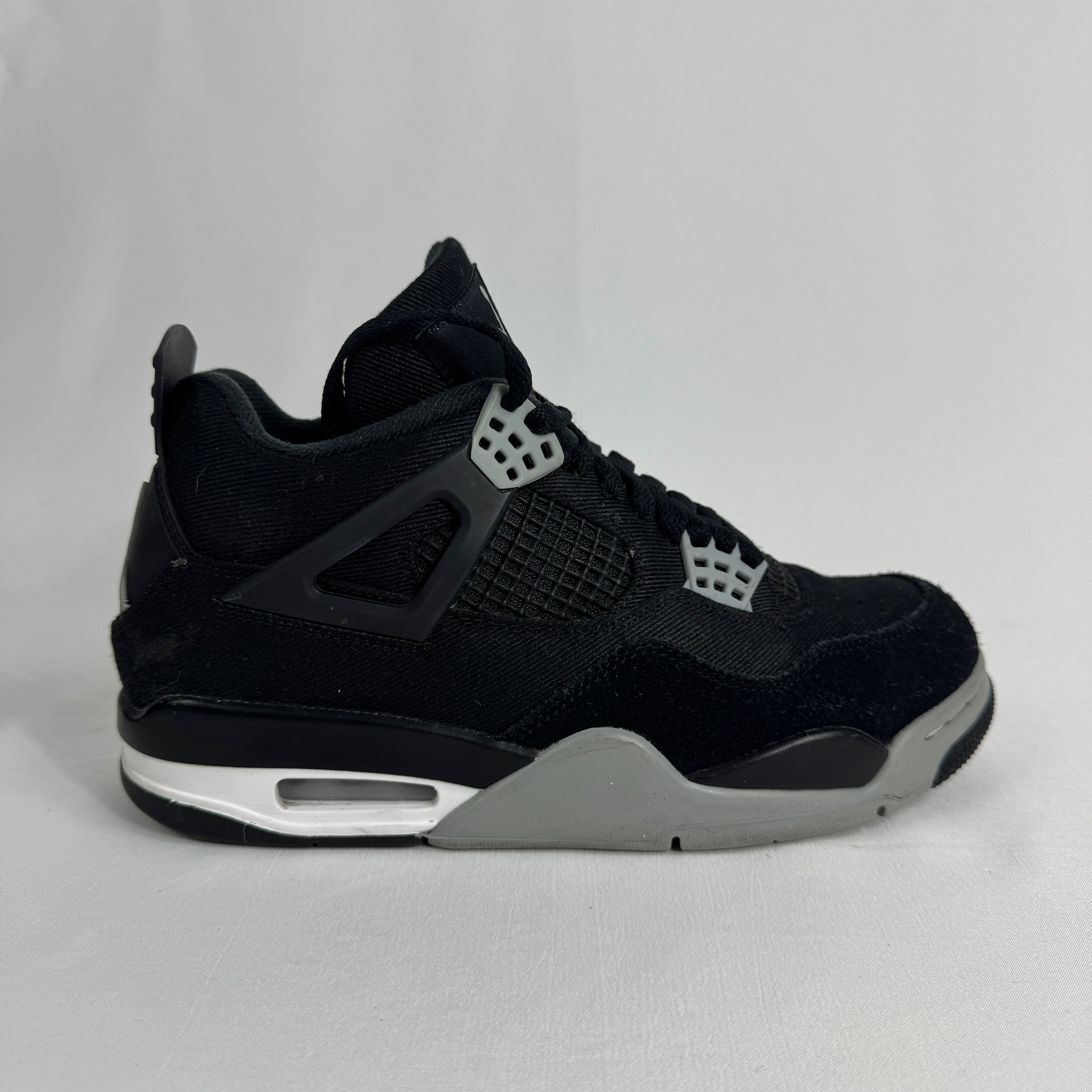 The Nike Air Jordan 4 Black Canvas is a versatile sneaker featuring a durable black canvas upper, suede accents, and