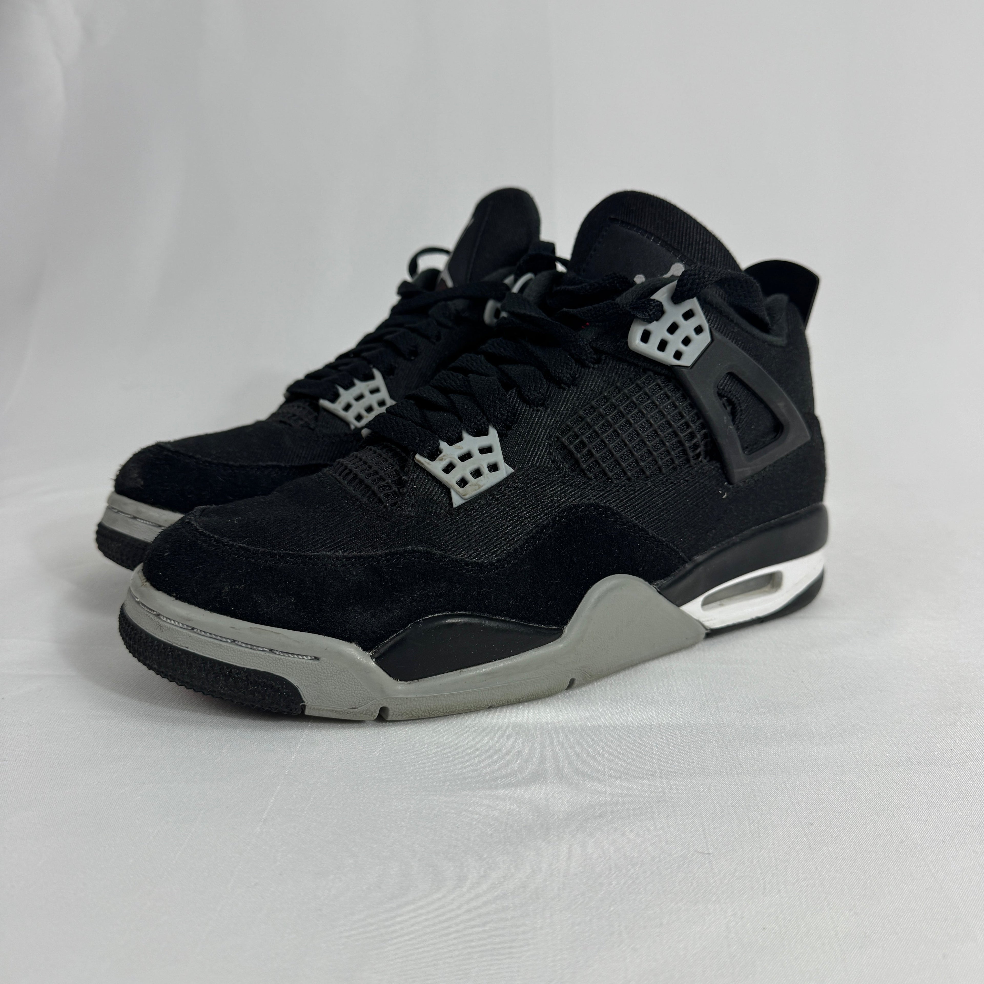 The Nike Air Jordan 4 Black Canvas is a versatile sneaker featuring a durable black canvas upper, suede accents, and