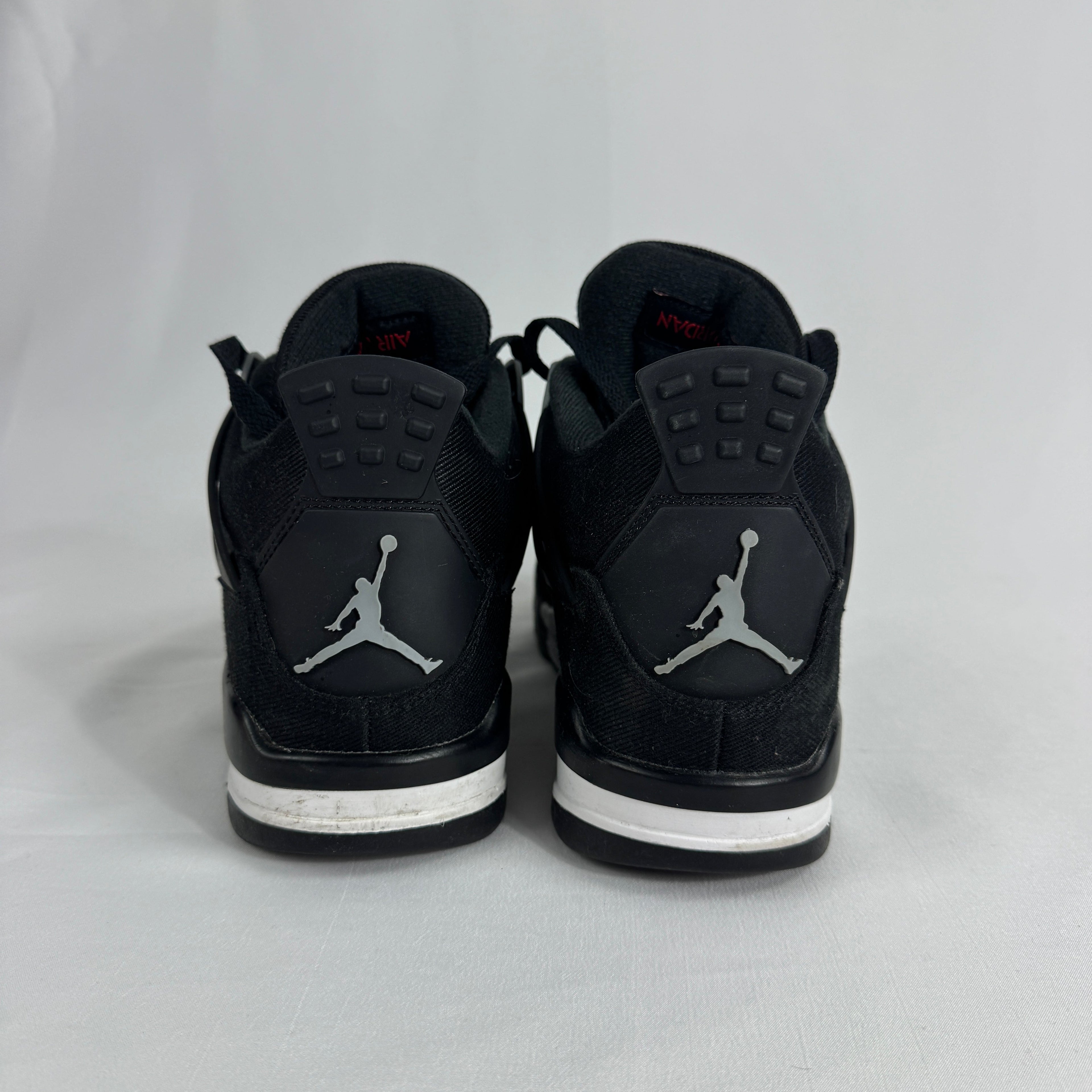 The Nike Air Jordan 4 Black Canvas is a versatile sneaker featuring a durable black canvas upper, suede accents, and