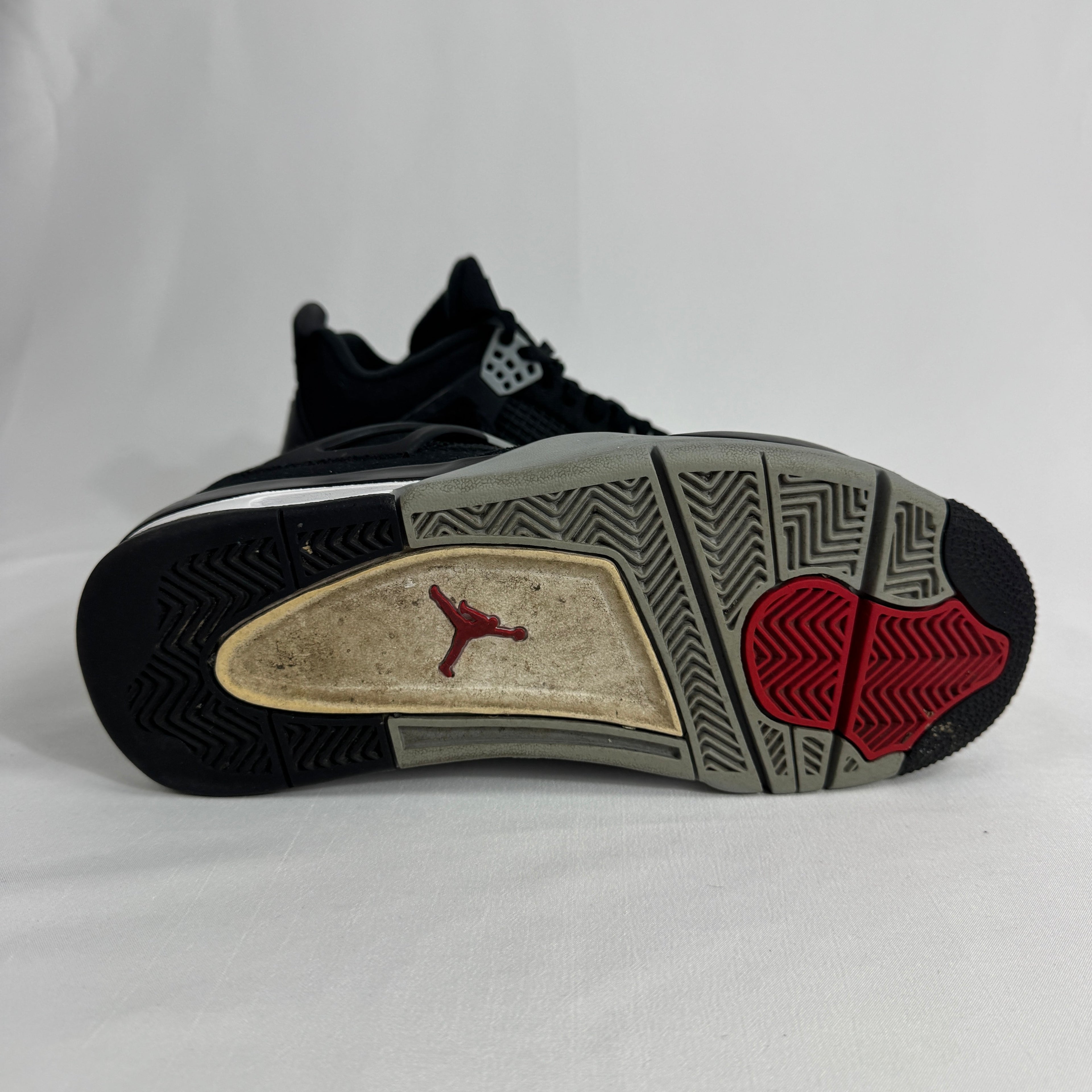 The Nike Air Jordan 4 Black Canvas is a versatile sneaker featuring a durable black canvas upper, suede accents, and