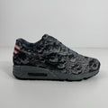 Nike trainer in grey with a moon-like textured upper, grey laces, Lunarlon sole and a small American flag on the heel.