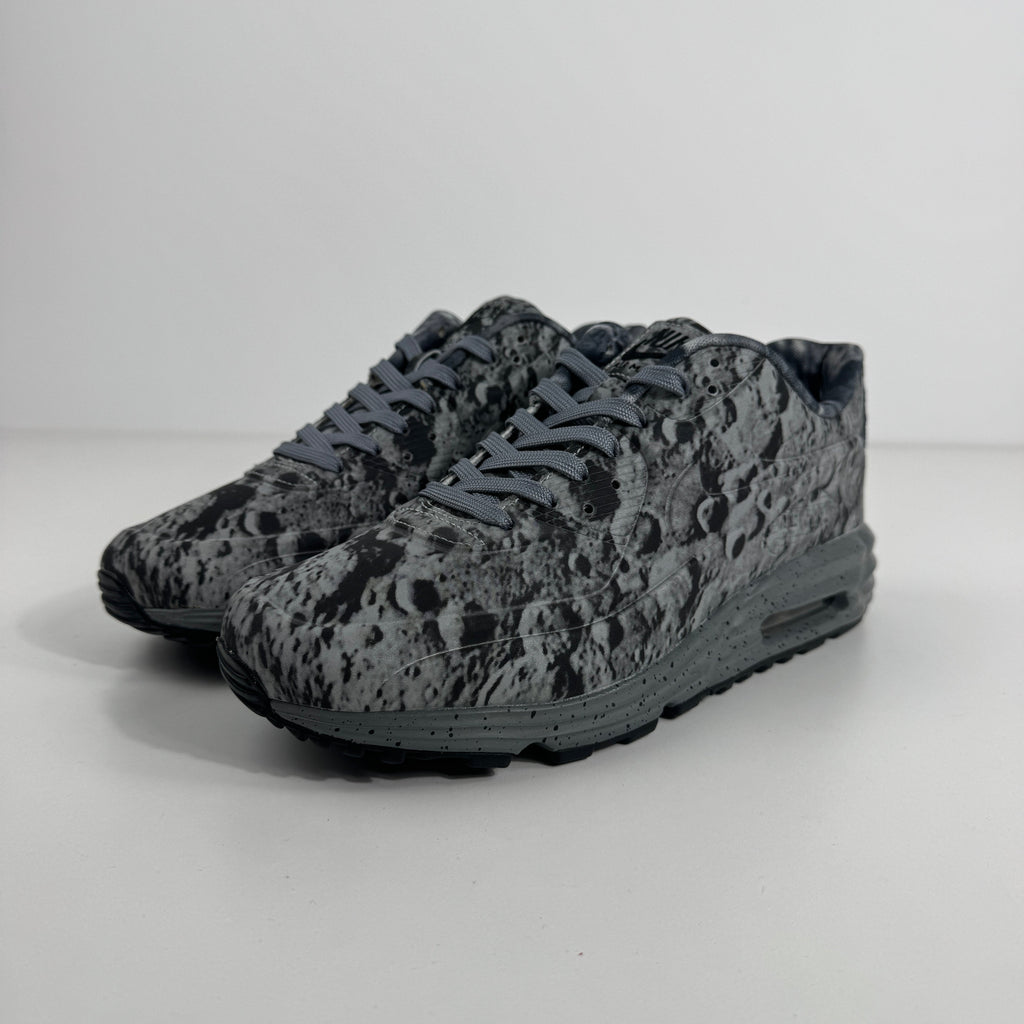 Nike Air Max Lunar90 SP trainers in grey and black with crater-like patterns, displayed on a plain white background.