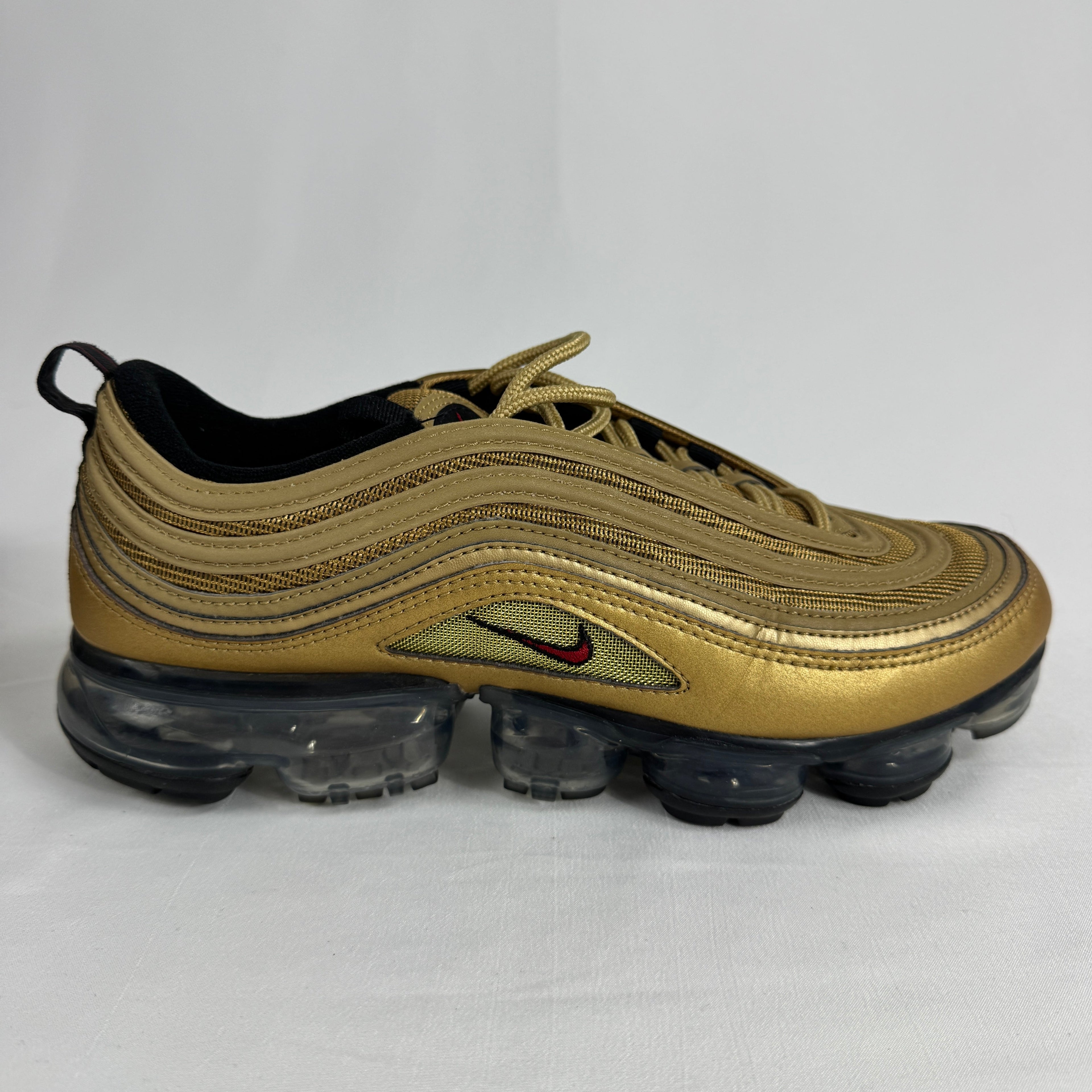 The Nike Air VaporMax 97 Metallic Gold combines the iconic Air Max 97 design with full-length VaporMax cushioning, featuring