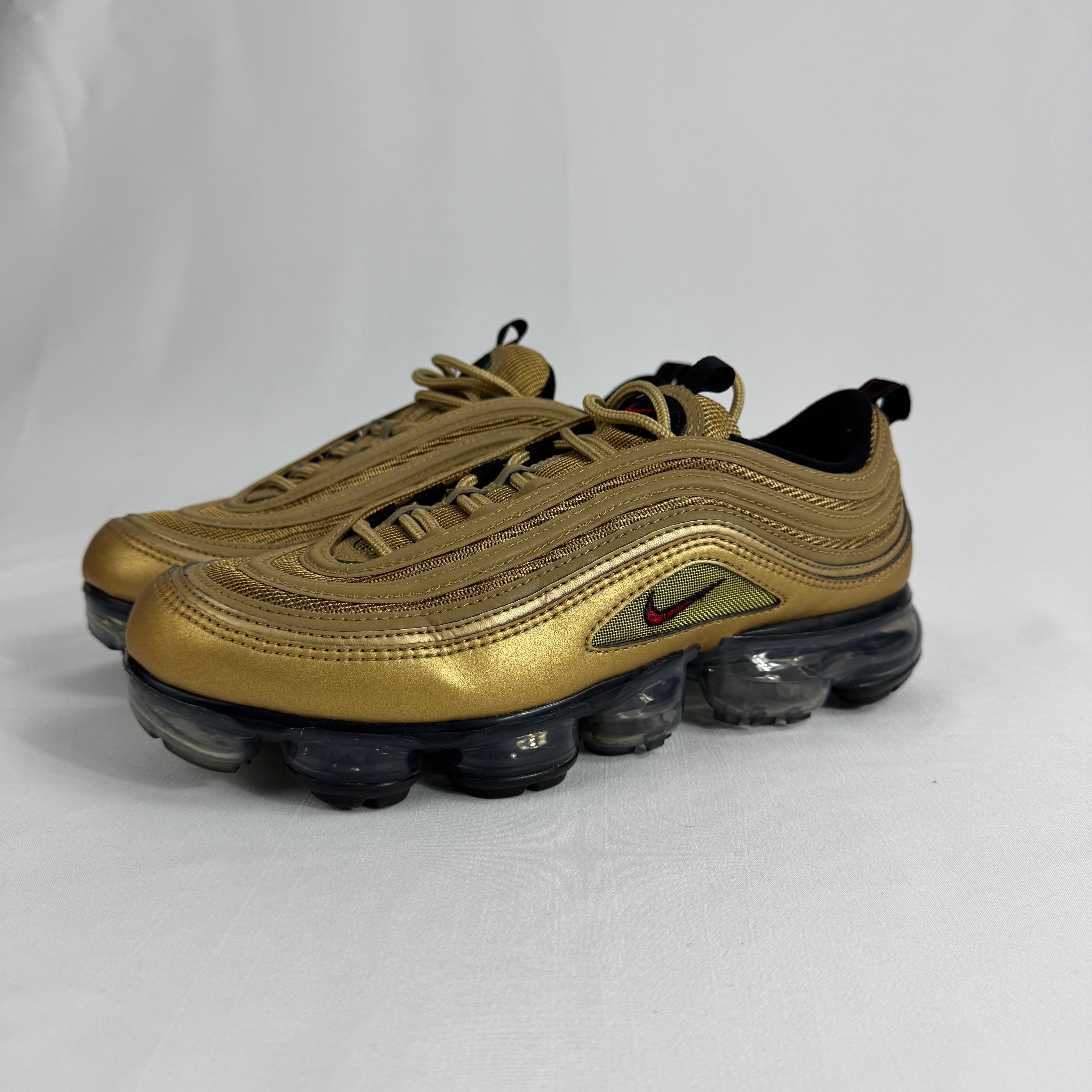 The Nike Air VaporMax 97 Metallic Gold combines the iconic Air Max 97 design with full-length VaporMax cushioning, featuring