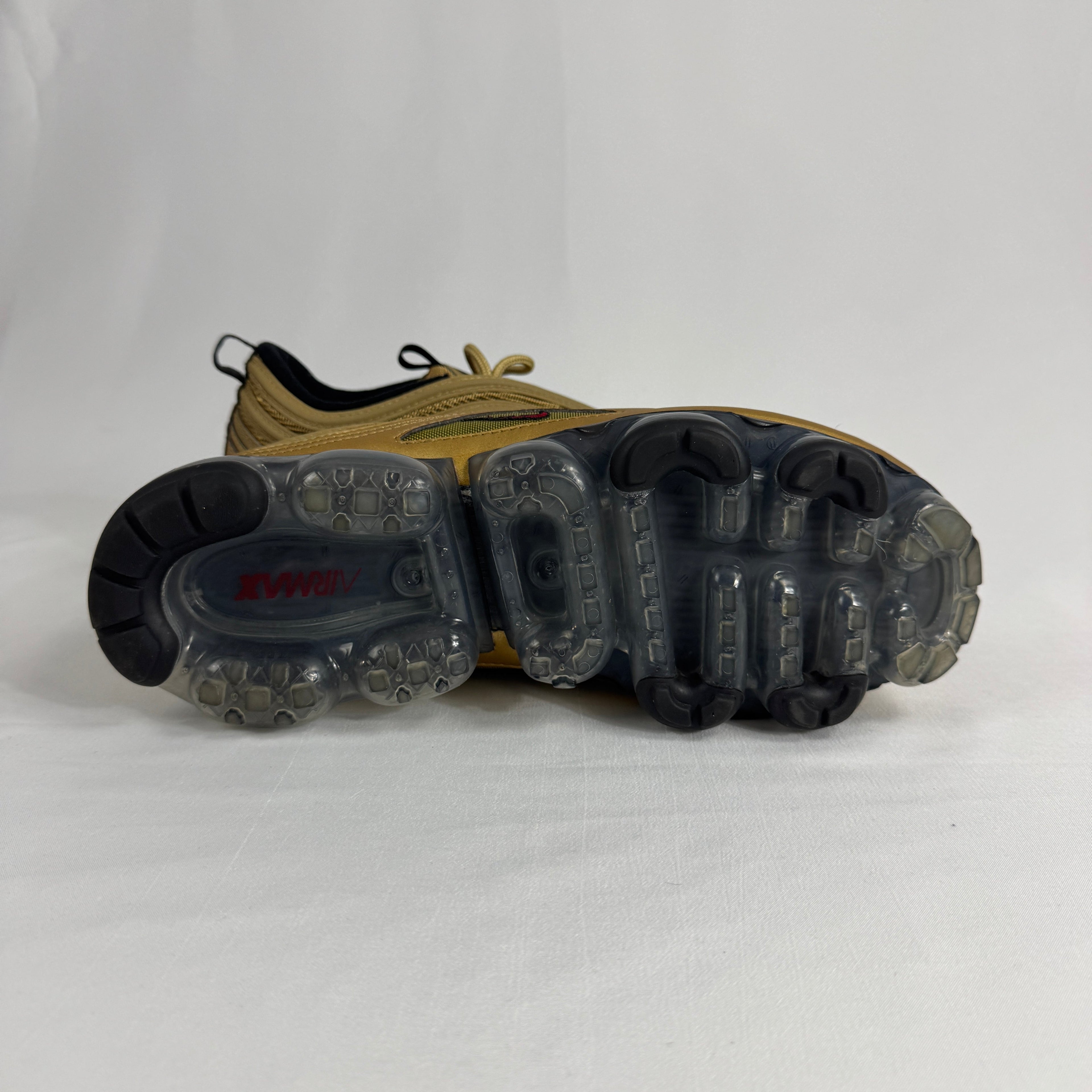 The Nike Air VaporMax 97 Metallic Gold combines the iconic Air Max 97 design with full-length VaporMax cushioning, featuring
