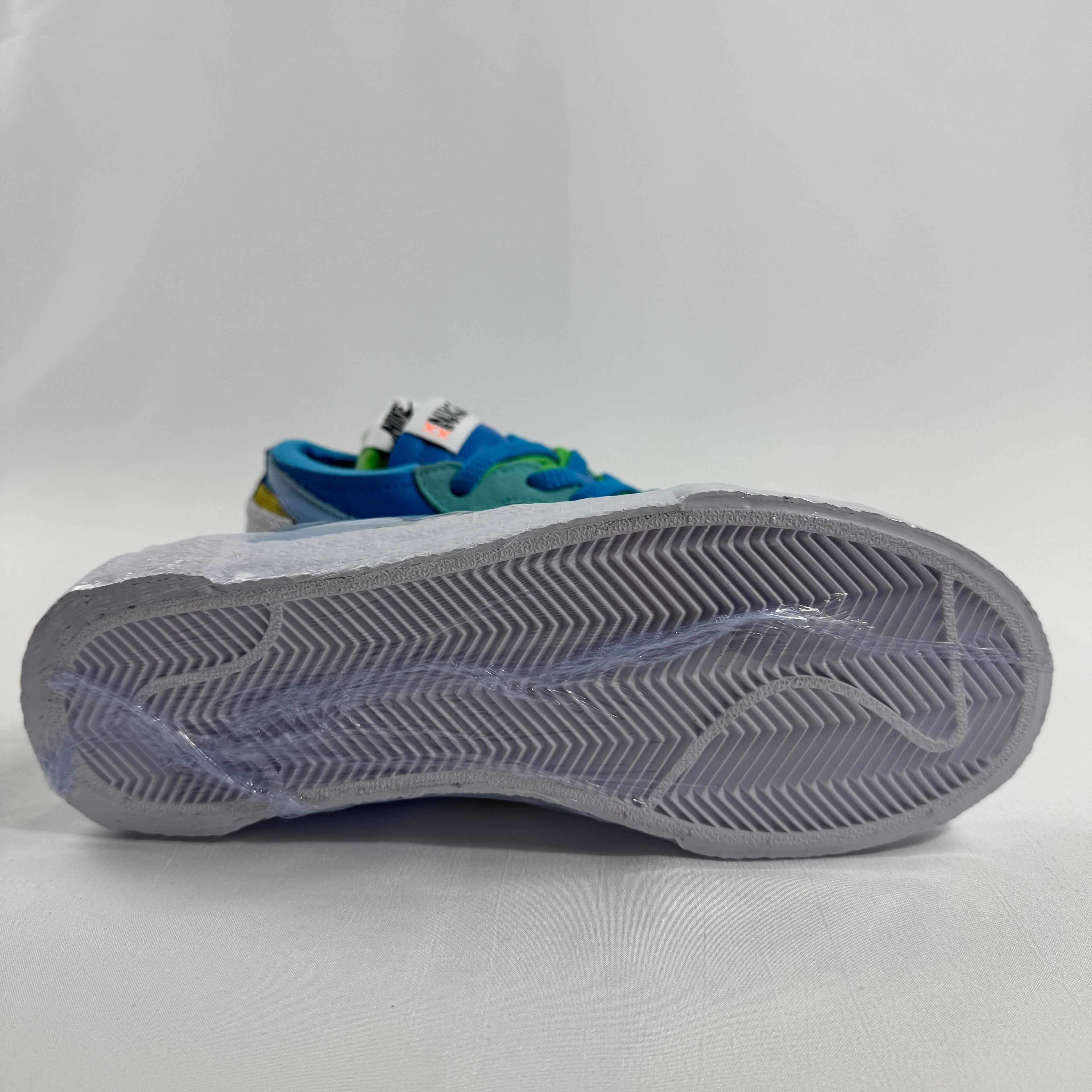 Nike Blazer Low / Sacai / KAWS is a collaborative reinterpretation of the classic Blazer Low, blending Sacai’s deconstructed