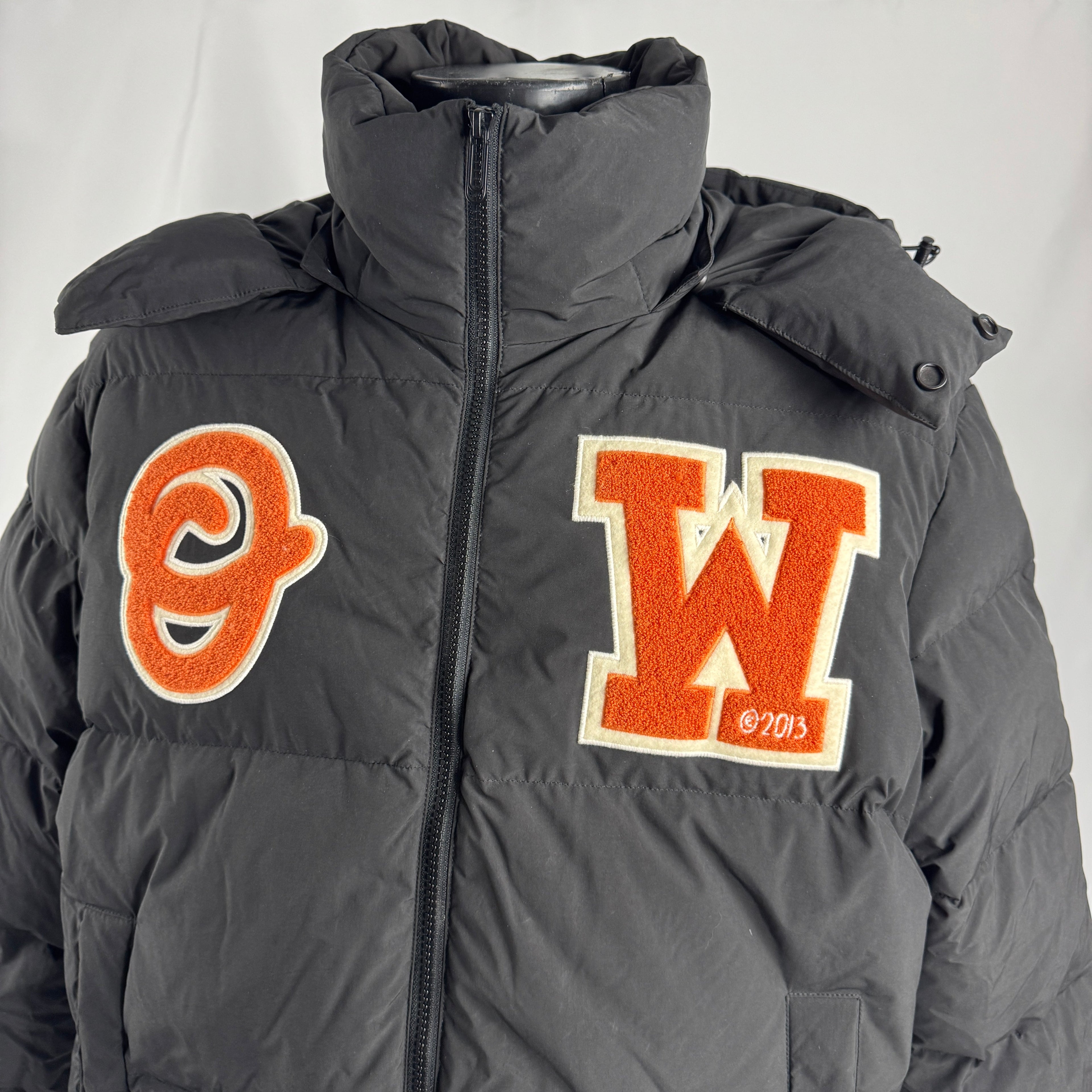 The Off-White Patch Puffer Jacket is a padded winter jacket featuring premium insulation, a relaxed fit, and signature