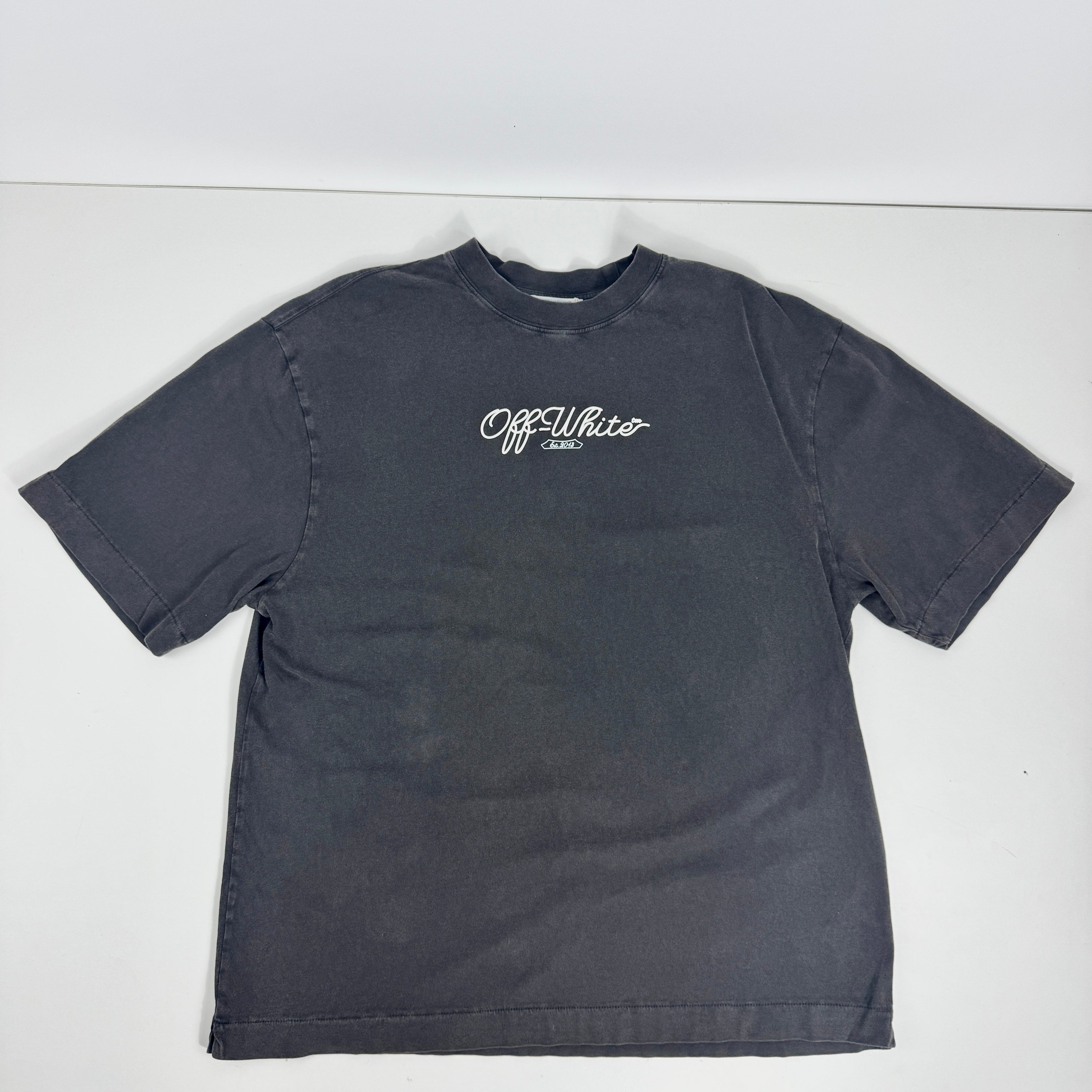 Off white tee features a heavyweight cotton construction with a vintage, washed black finish. The front displays a clean,