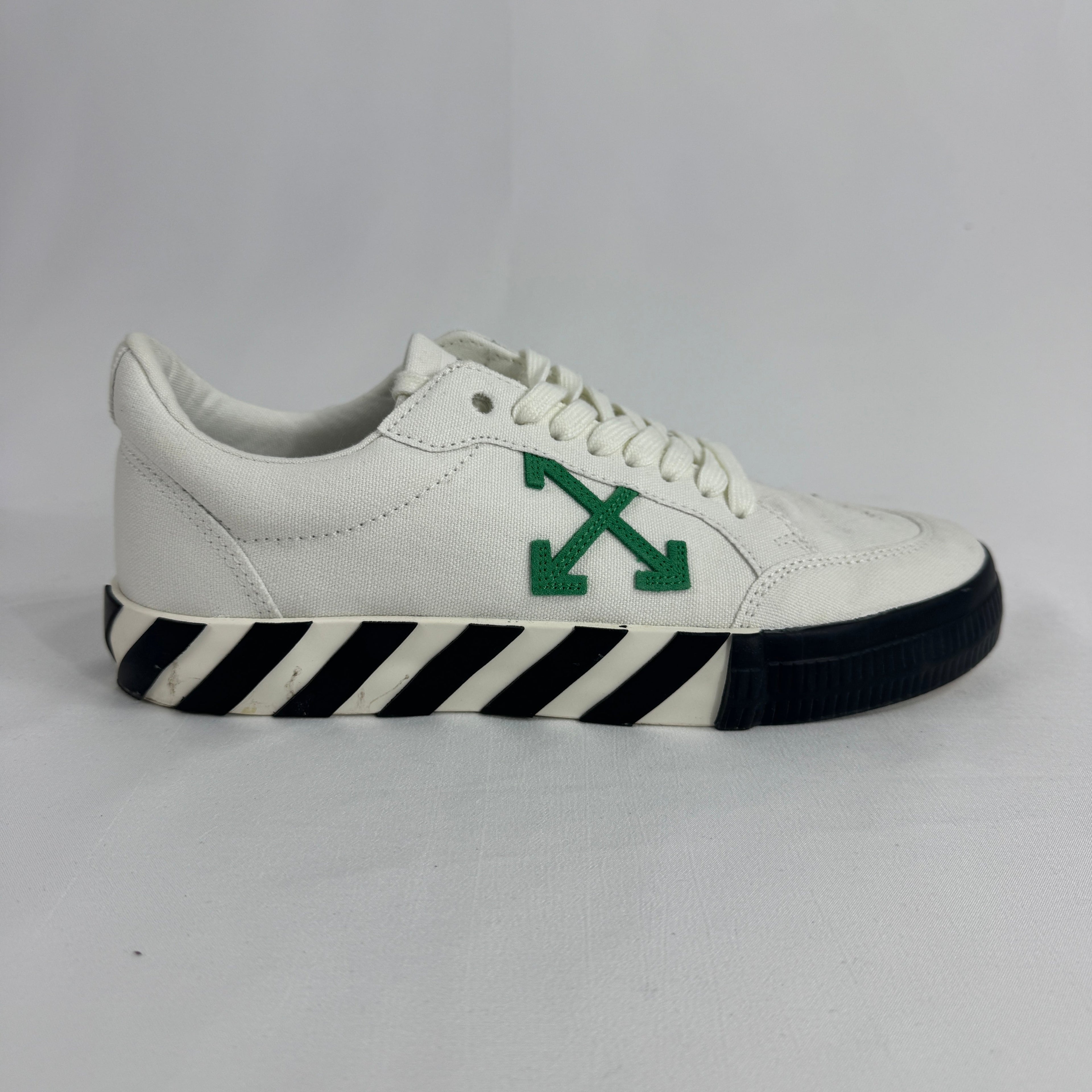 The Off-White Vulcanized Canvas White/Green is a low-top sneaker featuring a canvas upper with Virgil Abloh’s signature