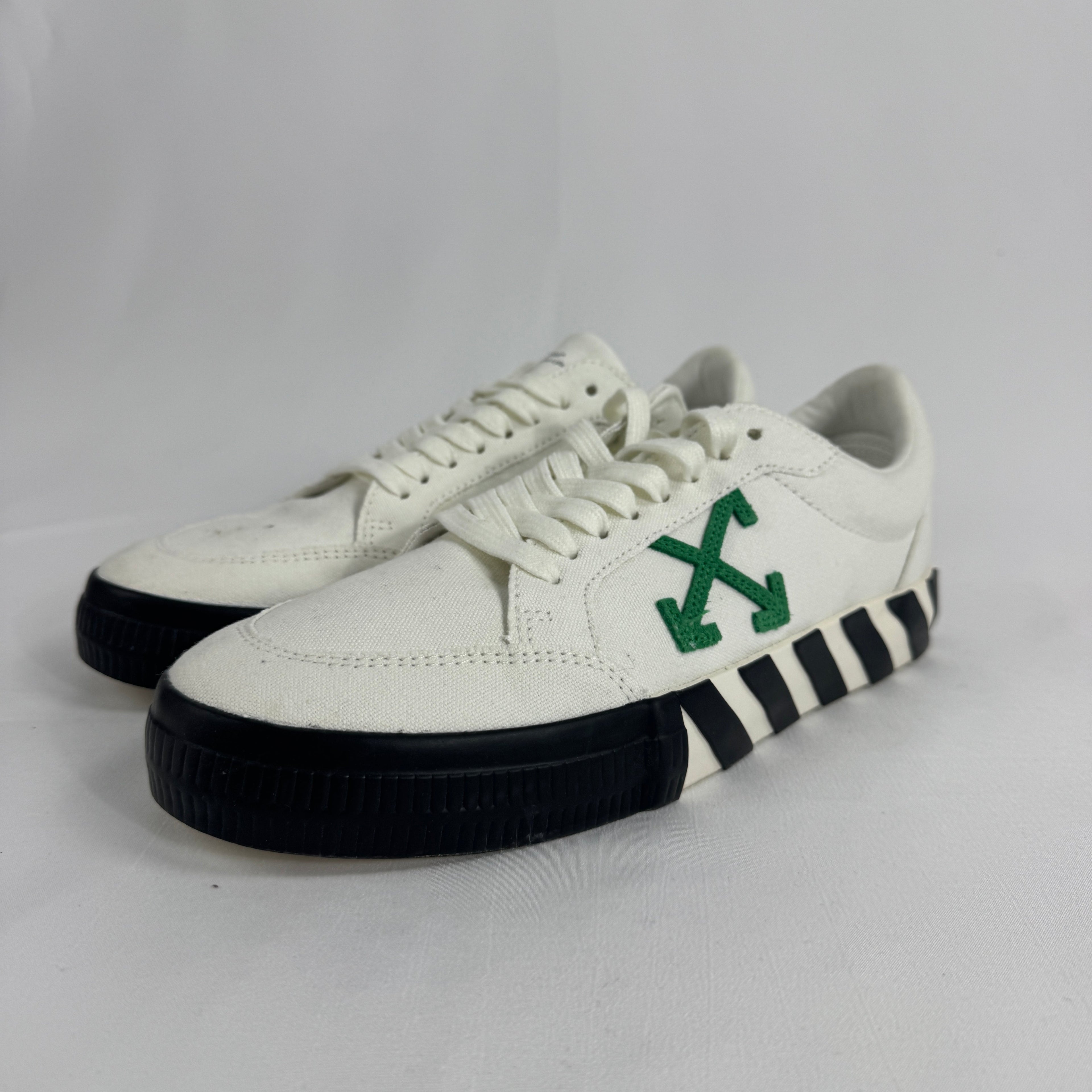 The Off-White Vulcanized Canvas White/Green is a low-top sneaker featuring a canvas upper with Virgil Abloh’s signature