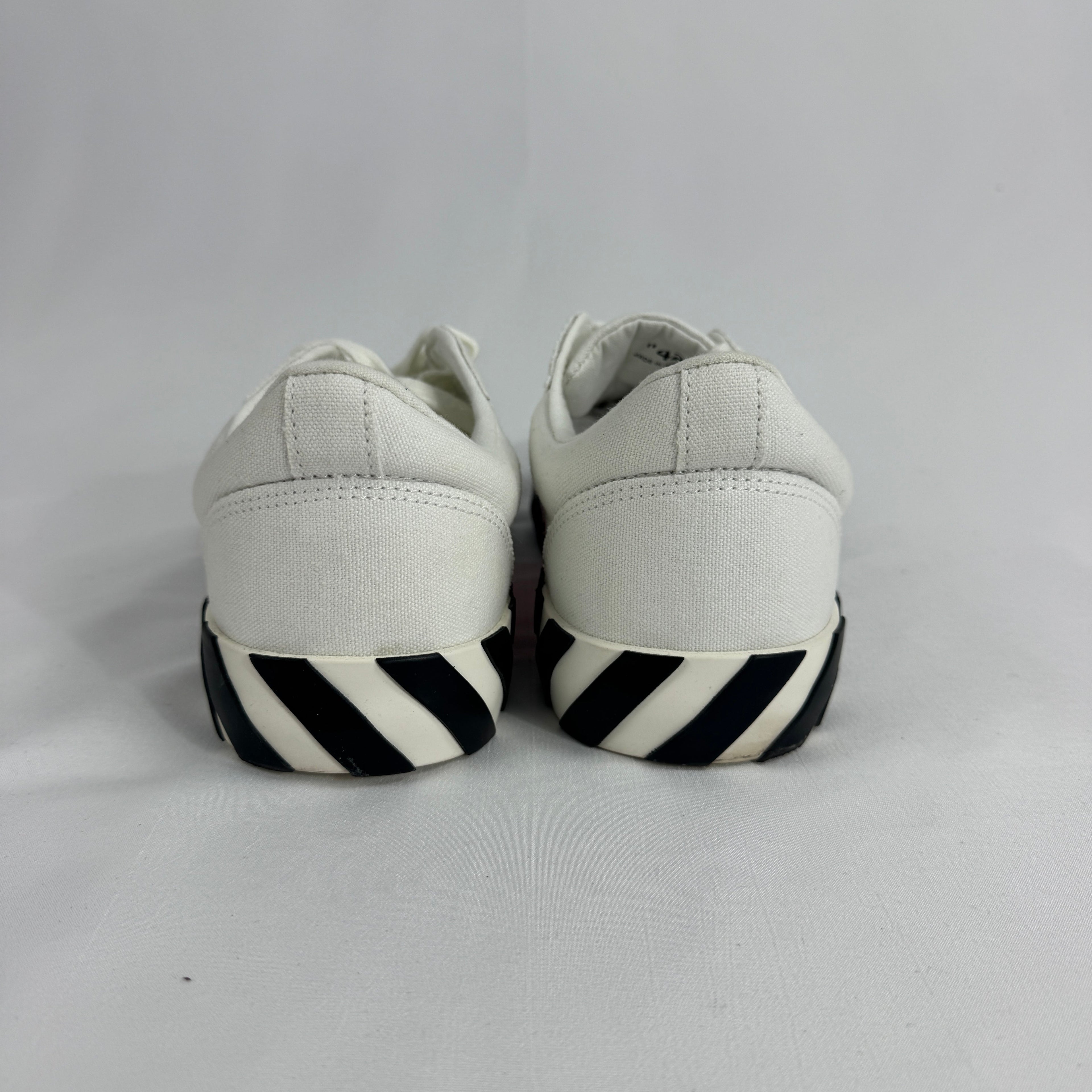 The Off-White Vulcanized Canvas White/Green is a low-top sneaker featuring a canvas upper with Virgil Abloh’s signature