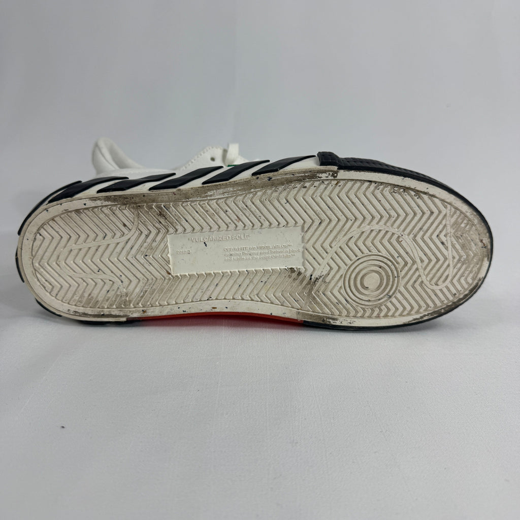 The Off-White Vulcanized Canvas White/Green is a low-top sneaker featuring a canvas upper with Virgil Abloh’s signature