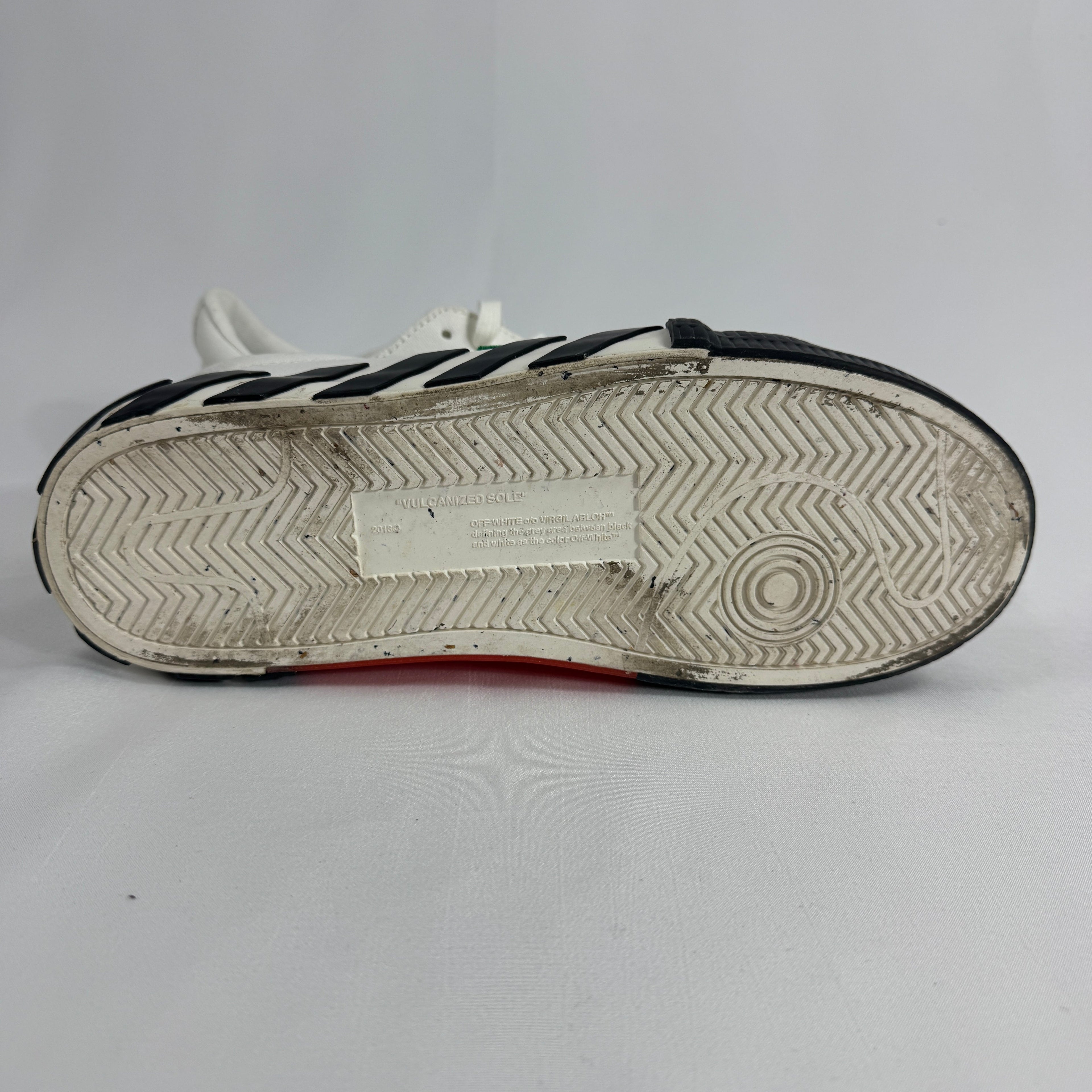 The Off-White Vulcanized Canvas White/Green is a low-top sneaker featuring a canvas upper with Virgil Abloh’s signature
