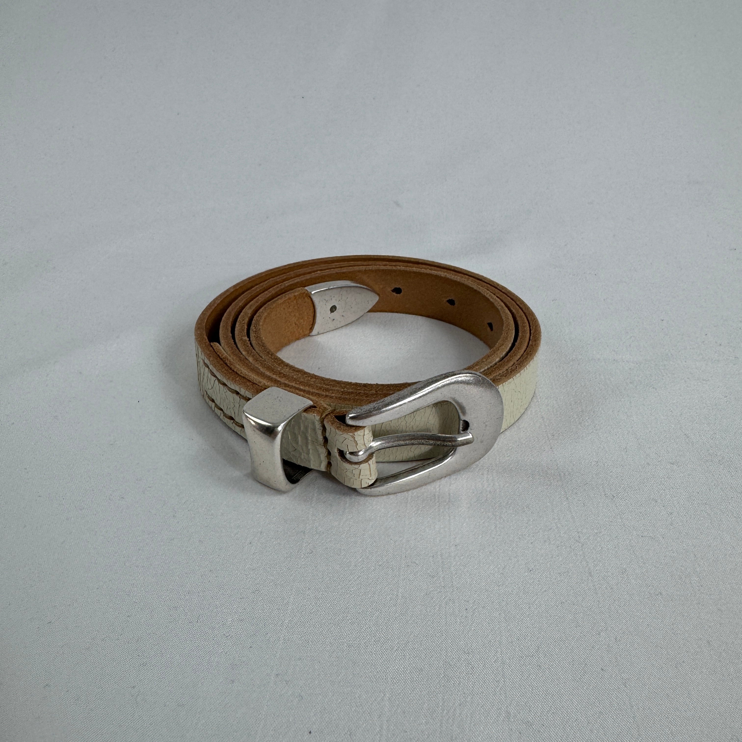 The Our Legacy White Belt Cracked is a premium leather belt crafted from cracked-finish leather for a distinctive worn-in