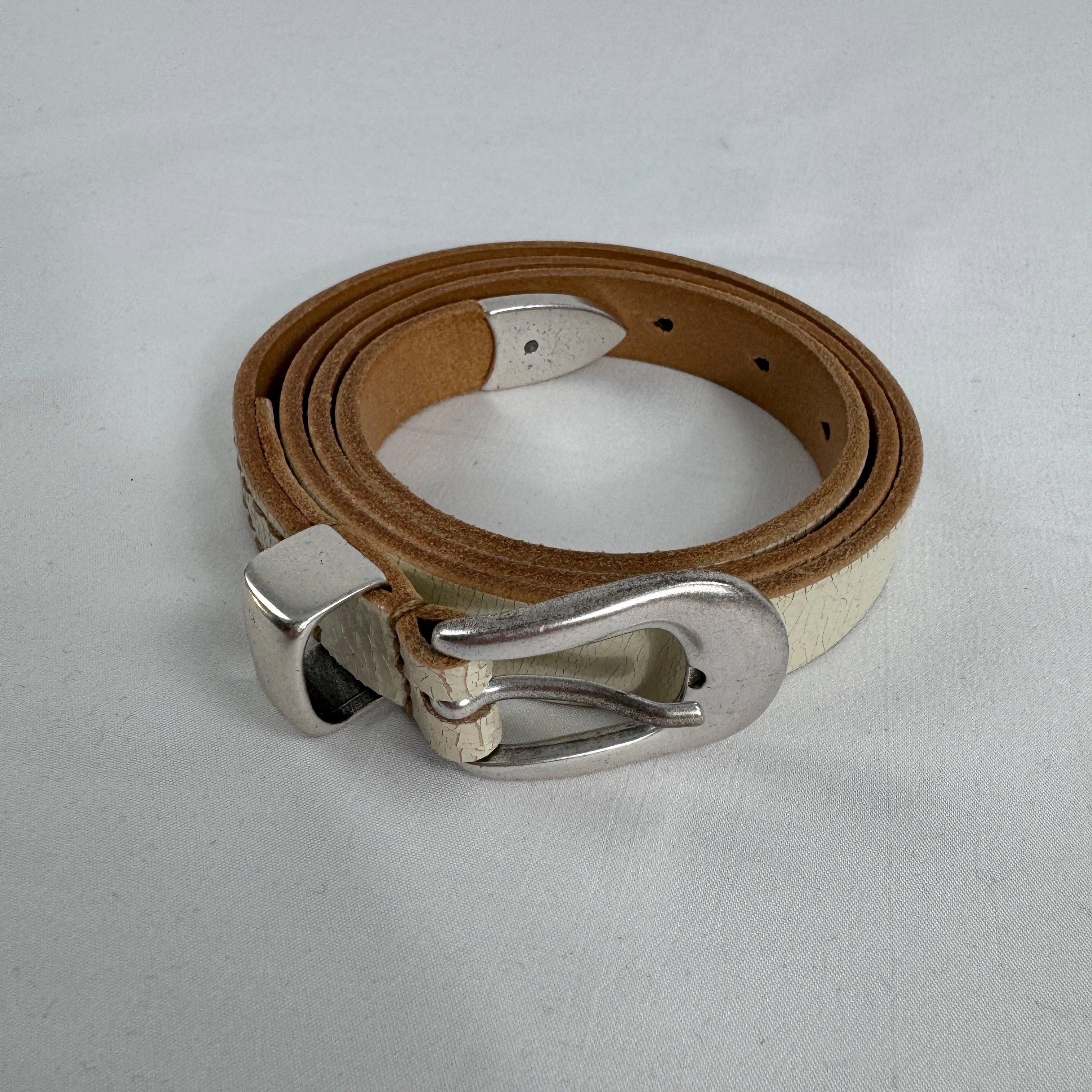 The Our Legacy White Belt Cracked is a premium leather belt crafted from cracked-finish leather for a distinctive worn-in