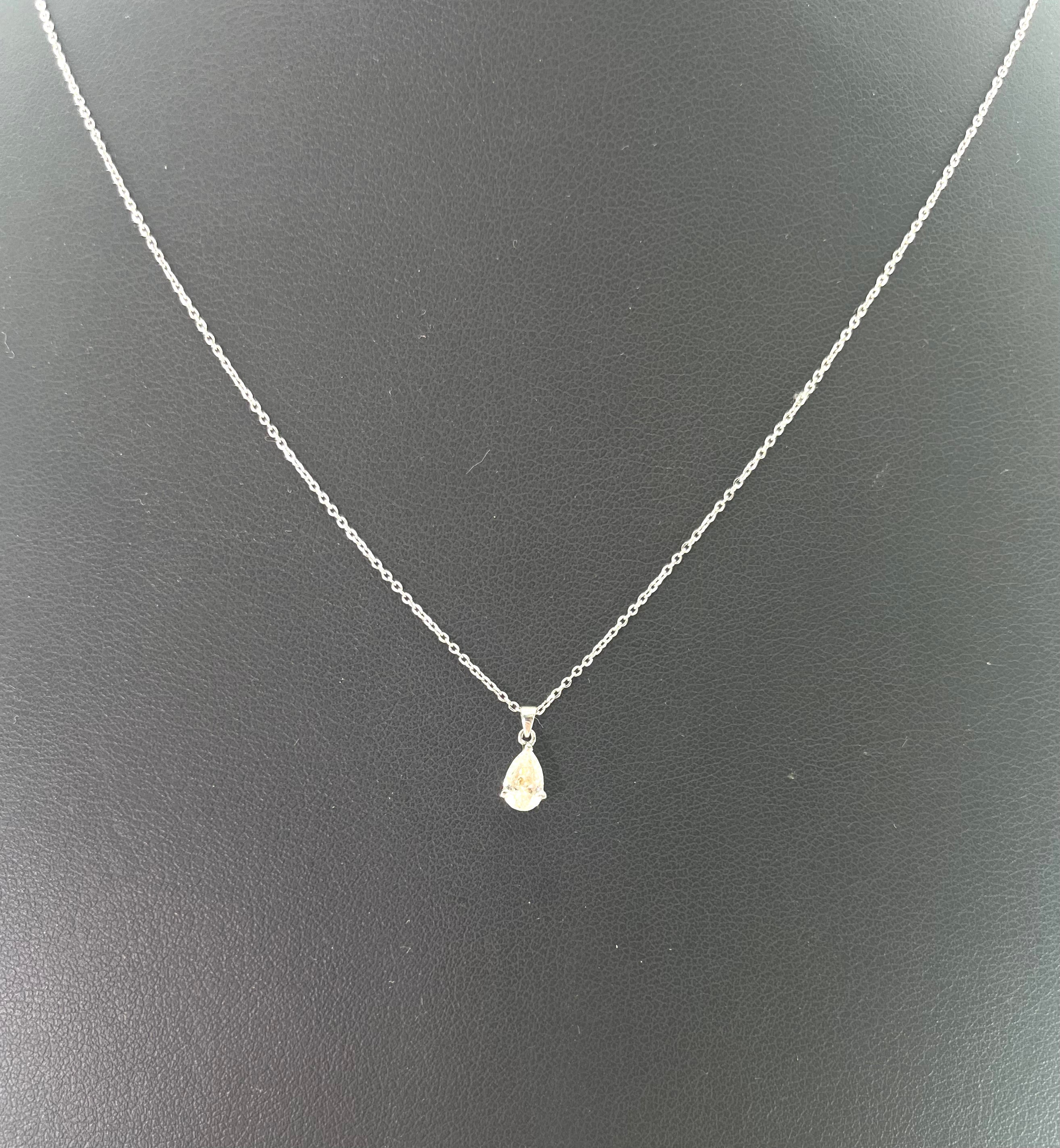 CB STORES pear-shaped diamond necklace in platinum shown against a plain black background.