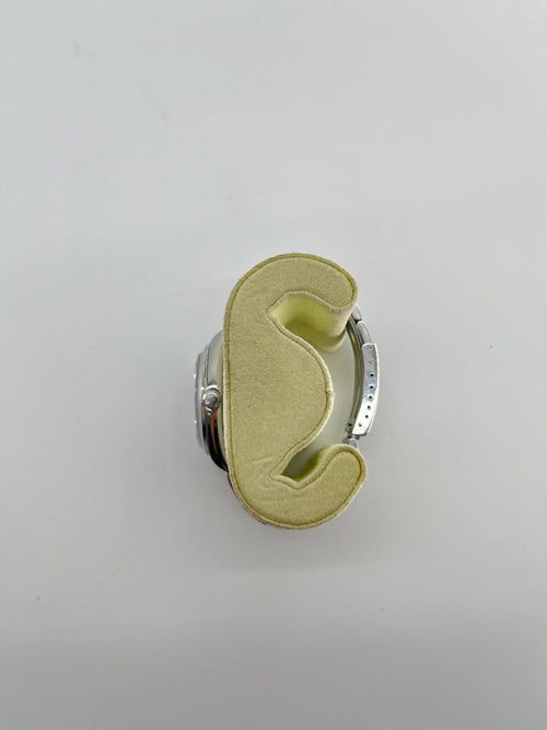 A Rolex Air-King watch with a stainless steel case is shown from above on a light yellow foam holder against a white background.