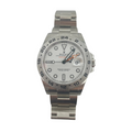 Rolex Explorer II silver wristwatch with a white dial, black markers and hands, orange GMT hand, date window, and metal link bracelet.