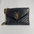 The Saint Laurent LouLou Crossbody Bag is a quilted leather handbag featuring the signature YSL logo, a chain strap, and a