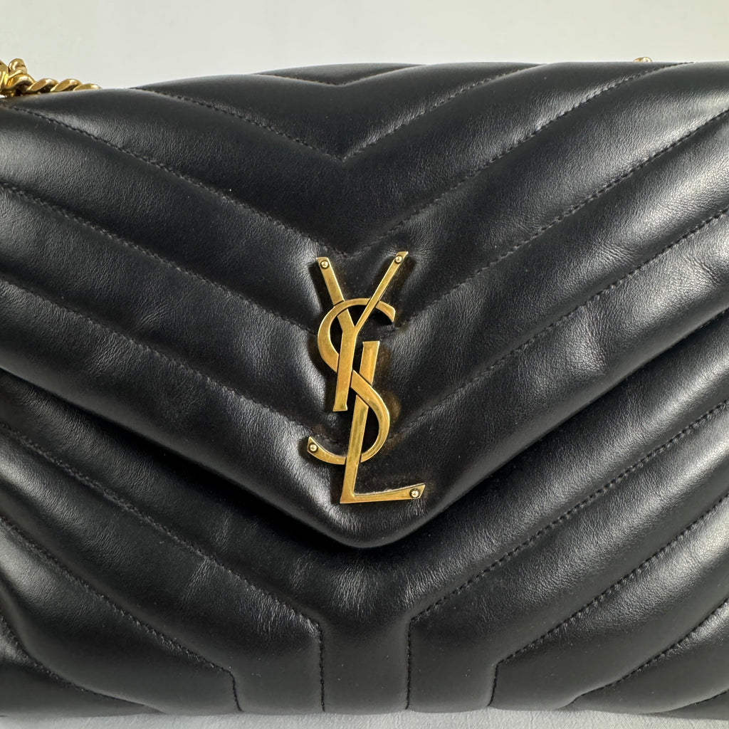 The Saint Laurent LouLou Crossbody Bag is a quilted leather handbag featuring the signature YSL logo, a chain strap, and a