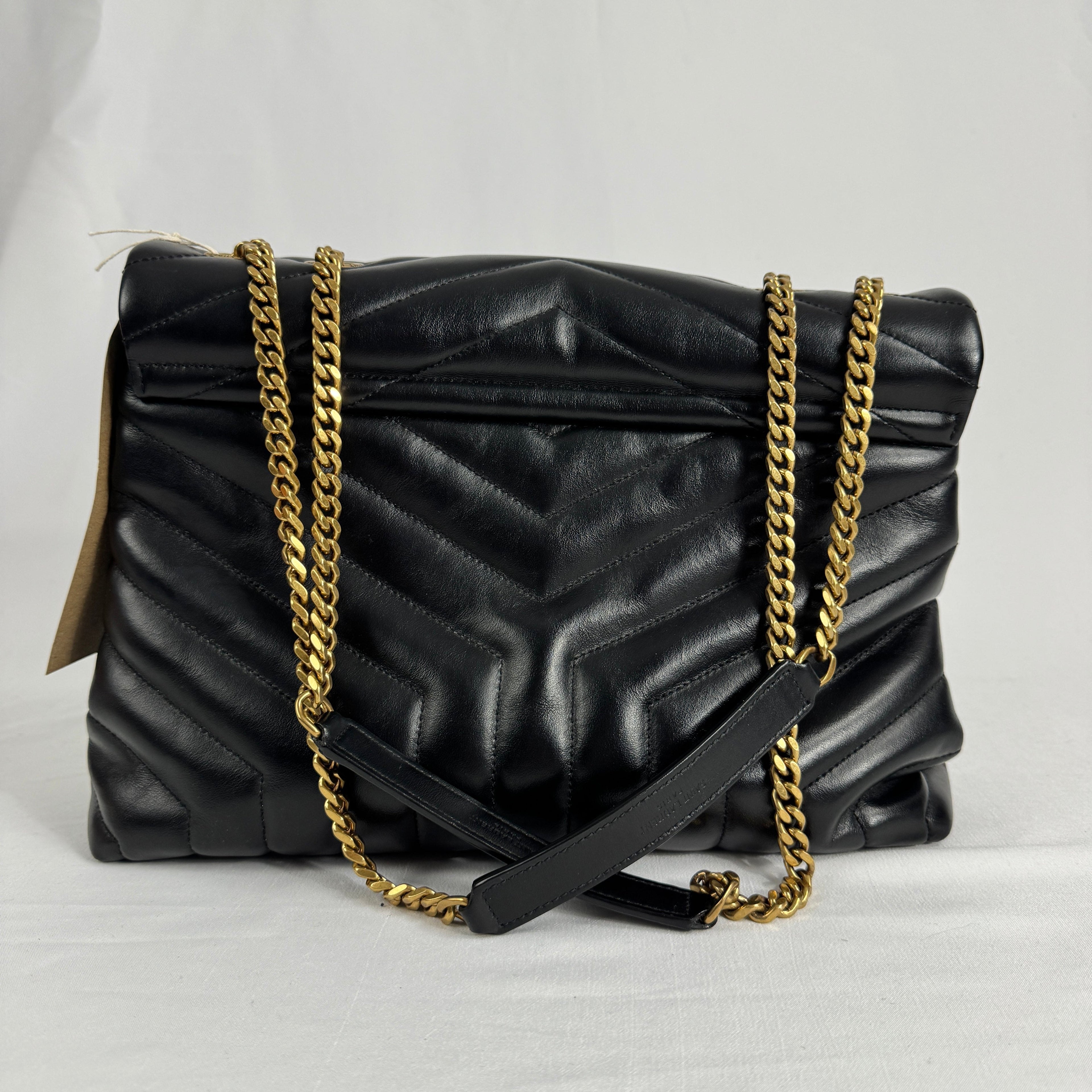 The Saint Laurent LouLou Crossbody Bag is a quilted leather handbag featuring the signature YSL logo, a chain strap, and a