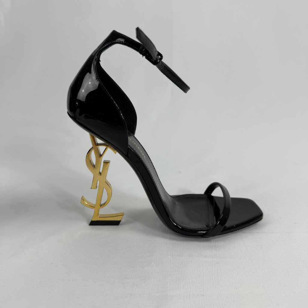 The Saint Laurent Opyum 110 is an iconic high-heel sandal renowned for its striking YSL logo heel. Crafted from premium