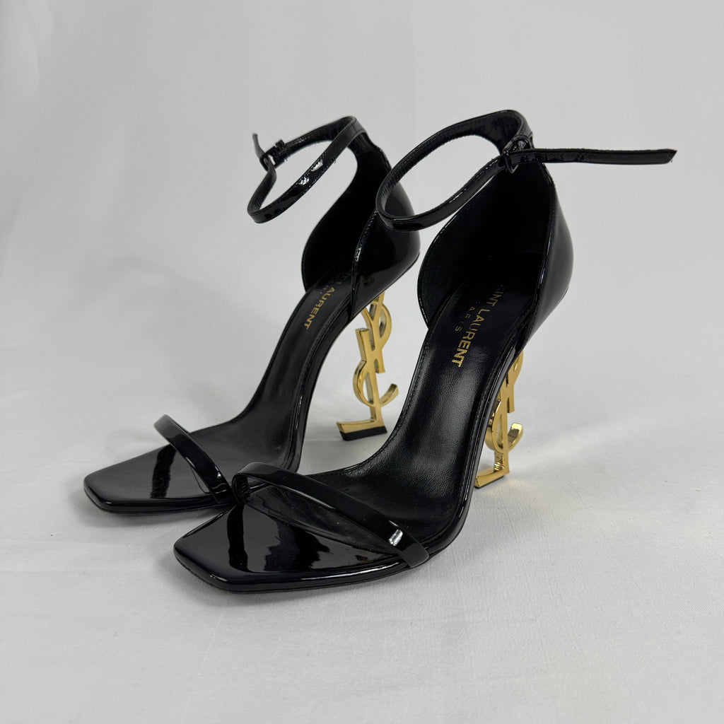 The Saint Laurent Opyum 110 is an iconic high-heel sandal renowned for its striking YSL logo heel. Crafted from premium