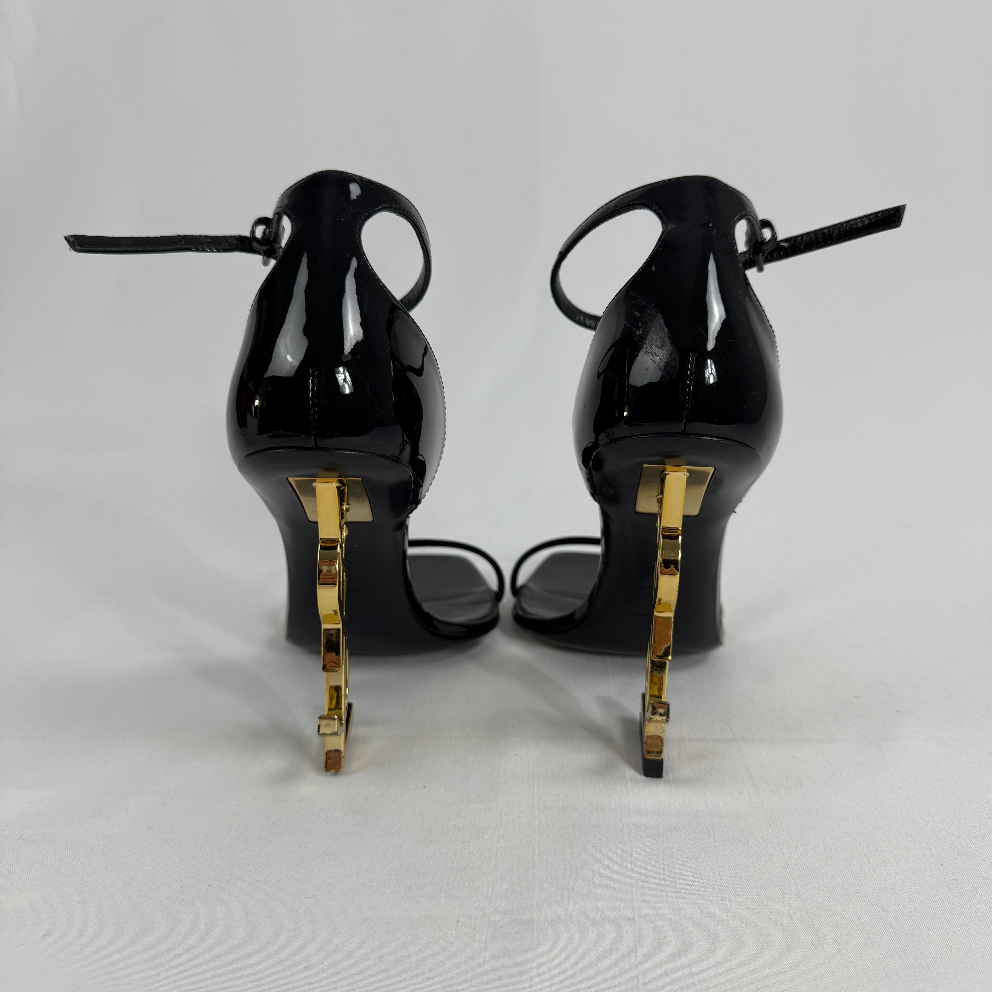 The Saint Laurent Opyum 110 is an iconic high-heel sandal renowned for its striking YSL logo heel. Crafted from premium