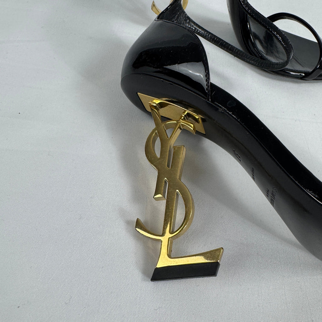 The Saint Laurent Opyum 110 is an iconic high-heel sandal renowned for its striking YSL logo heel. Crafted from premium