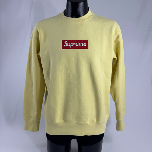 The Supreme Box Logo in pale yellow refers to a signature Supreme piece featuring the iconic box logo graphic set against a