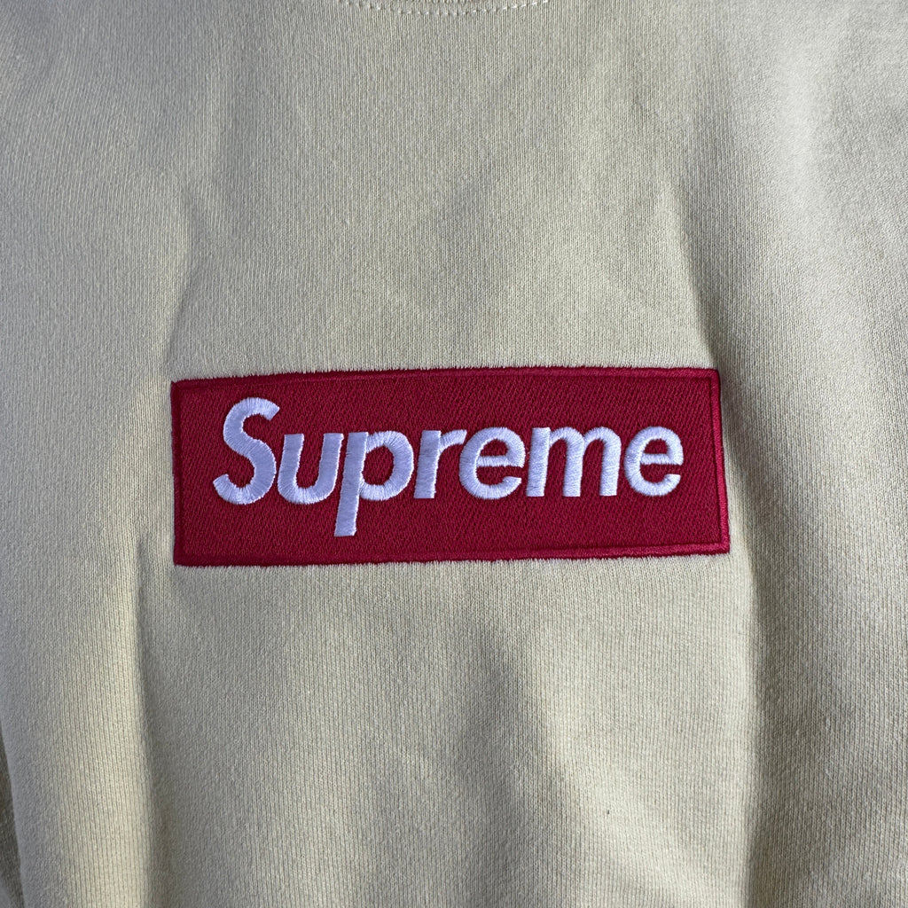 The Supreme Box Logo in pale yellow refers to a signature Supreme piece featuring the iconic box logo graphic set against a