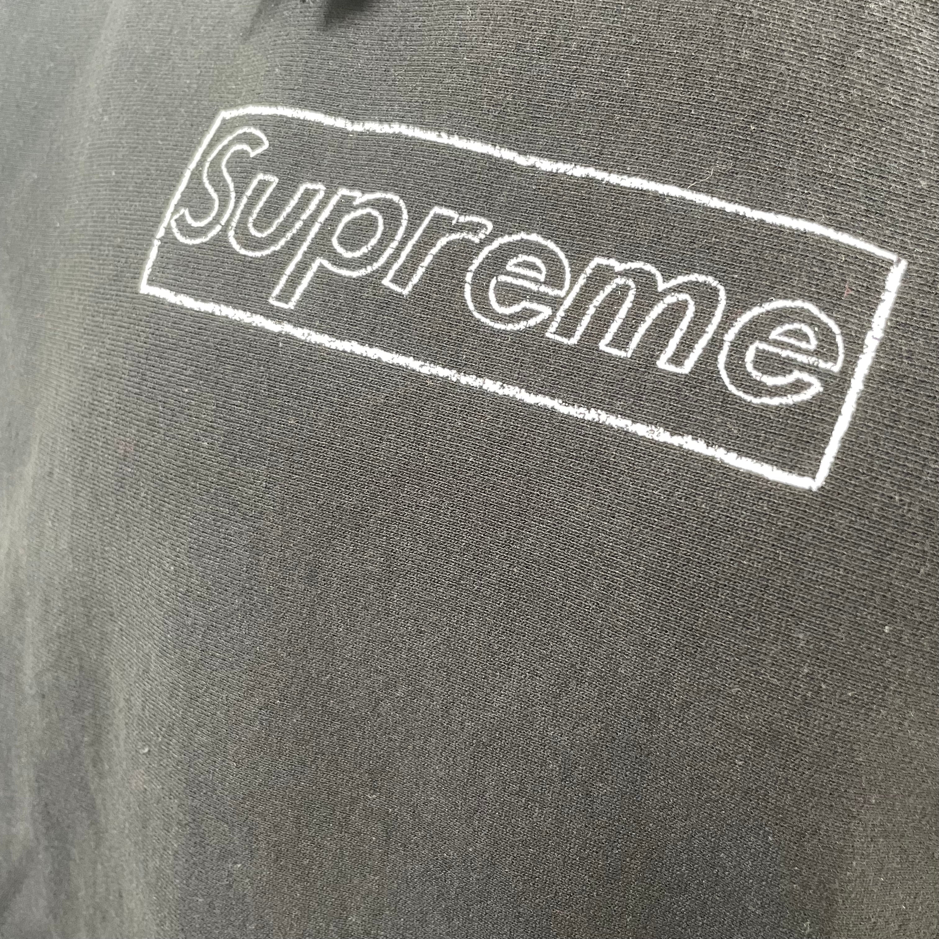 The Supreme KAWS Chalk Hooded Sweatshirt Black is a heavyweight cotton hoodie featuring KAWS’ signature chalk-style Box Logo