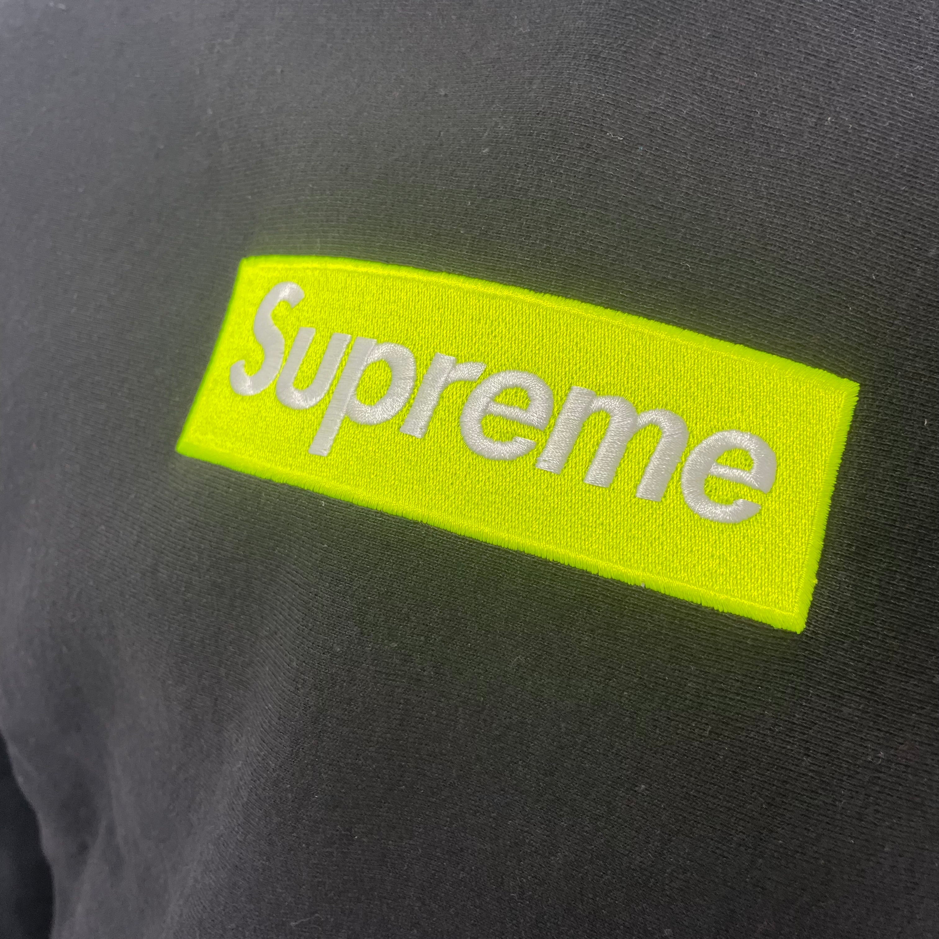 The Supreme Neon Box Logo Hoodie Black is a premium heavyweight cotton hoodie featuring the iconic box logo with a
