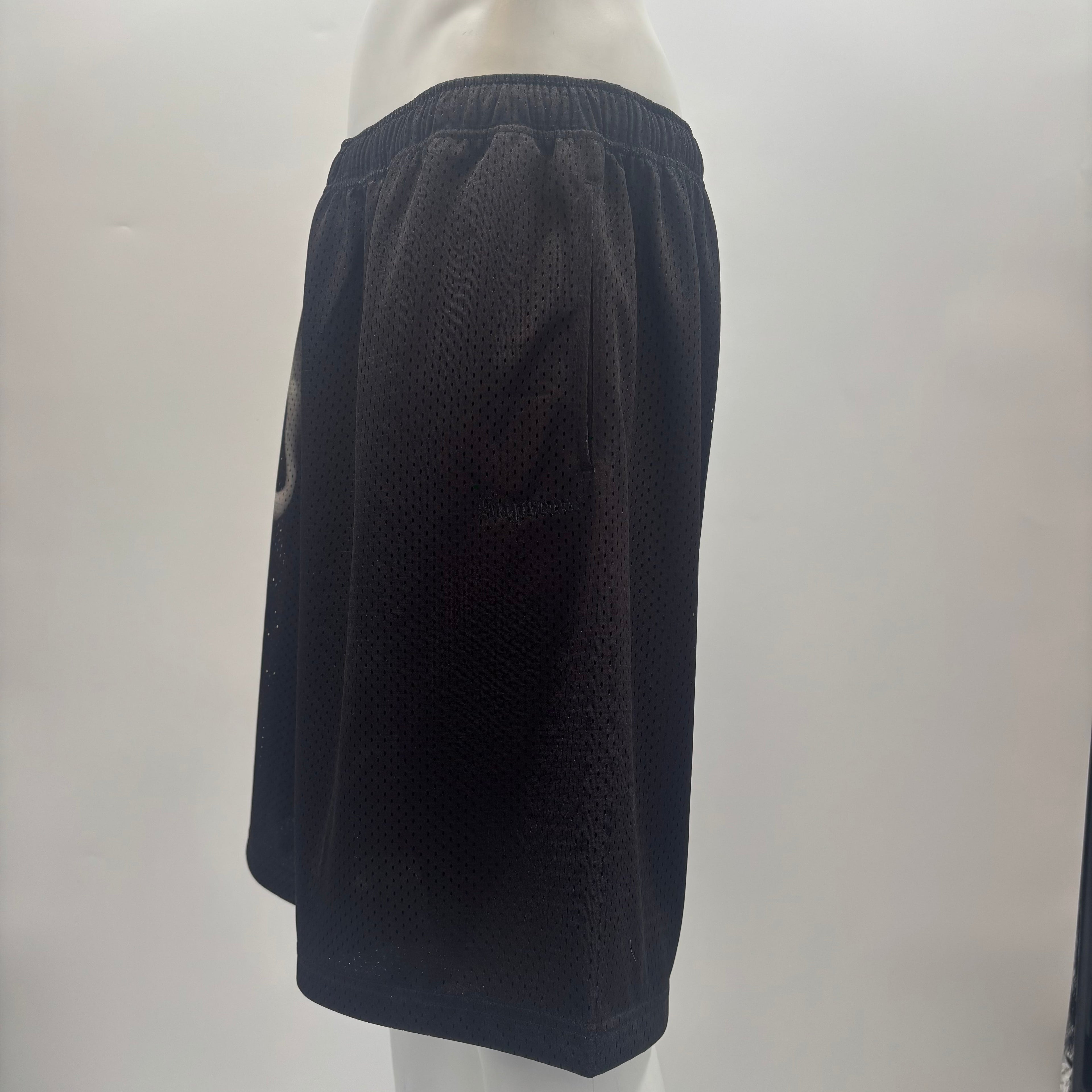 Side view of a mannequin wearing SUPREME X Ghostface shorts with an elastic waistband and mesh fabric, on a light background.