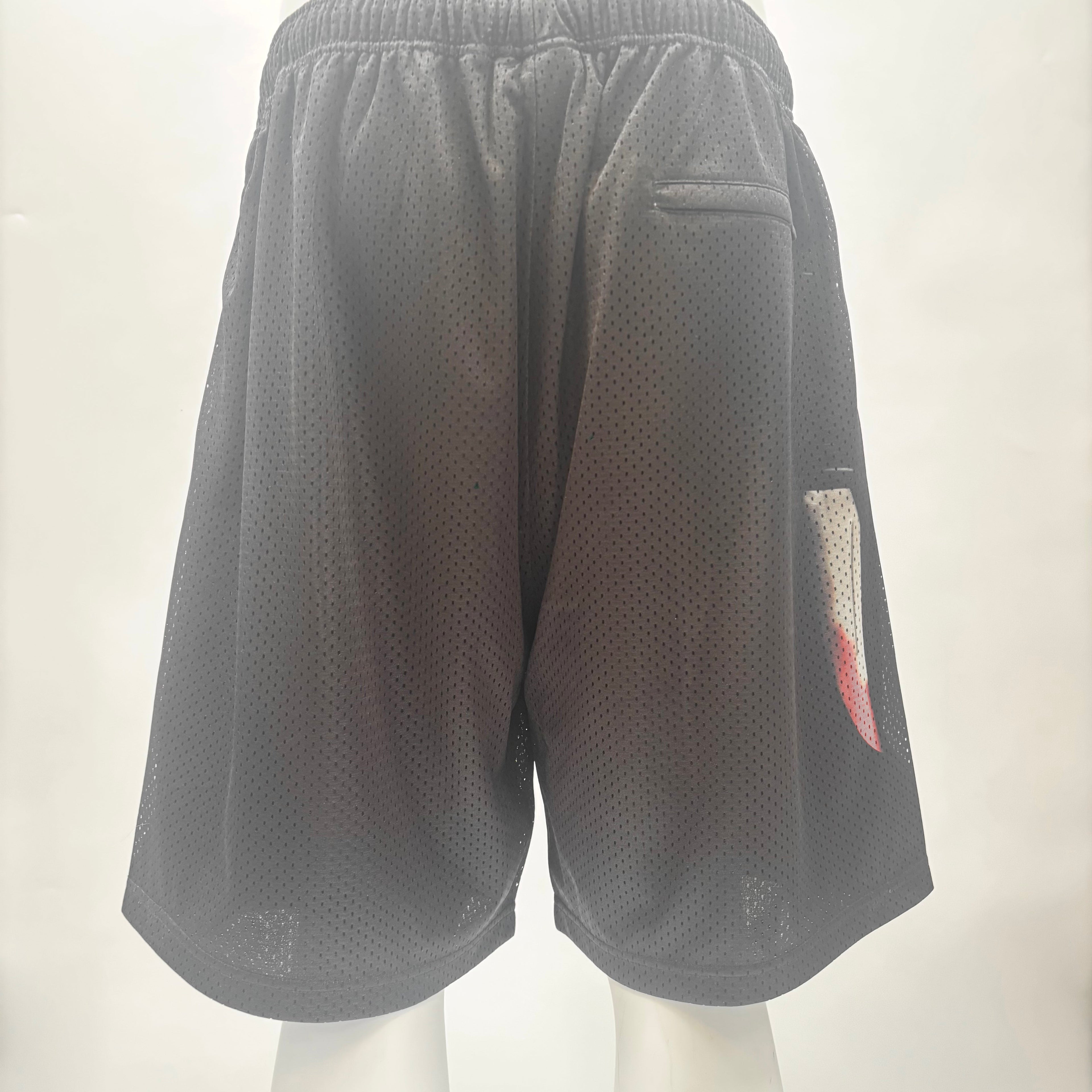 Back view of black SUPREME X Ghostface mesh shorts with elastic waistband, small back pocket, and colourful graphic on right leg.