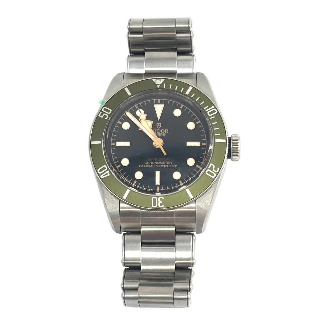 TUDOR Black Bay wristwatch with a black dial, green bezel, silver bracelet, white hour markers and gold hands.