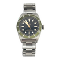 TUDOR Black Bay wristwatch with a black dial, green bezel, silver bracelet, white hour markers and gold hands.